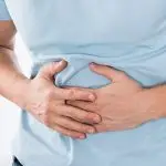 A man clutching his stomach with digestive pain