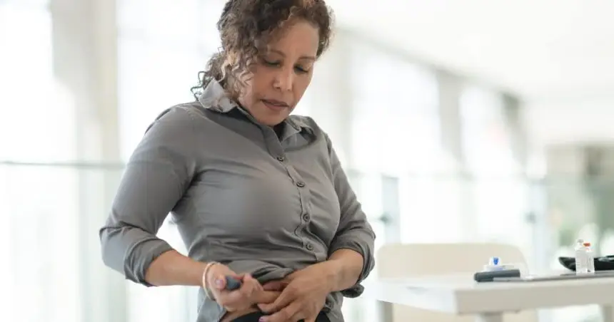 Image of a women injecting a medication pen into her stomach