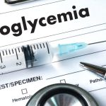 Word hypoglycemia on a diagnosis sheet with a pen and syringe