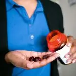 a photo of someone pouring elderberry gummies into their hand