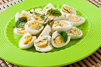 Boiled quail eggs halves on a green plate