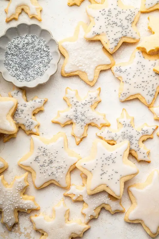 Multiple gluten free sugar cookies decorated with icing and sprinkles.