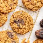 Oatmeal date cookies on a gold wire cooling rack.