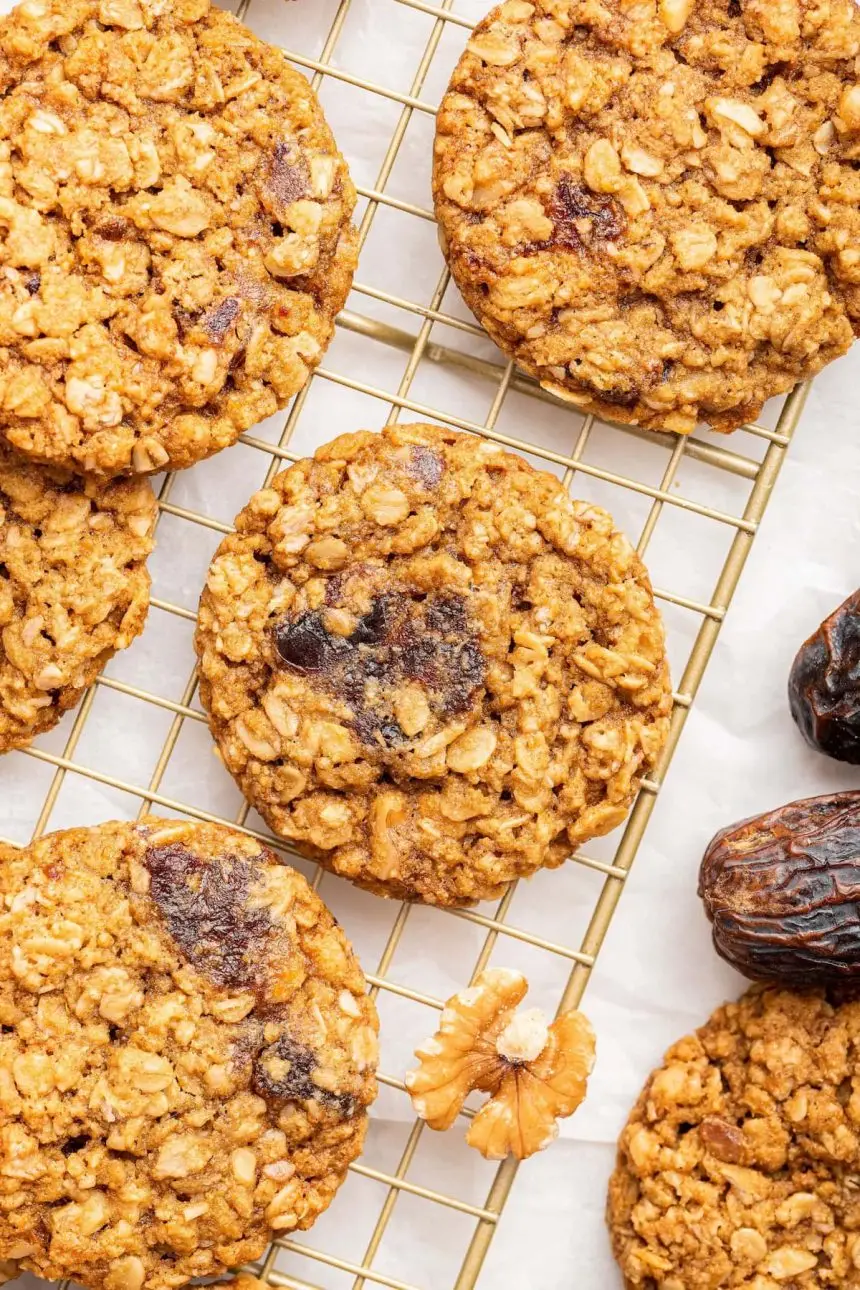 Oatmeal date cookies on a gold wire cooling rack.