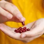 Person holds red vitamins