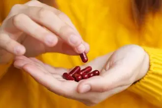 Person holds red vitamins