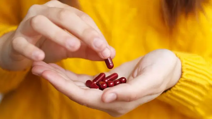 Person holds red vitamins