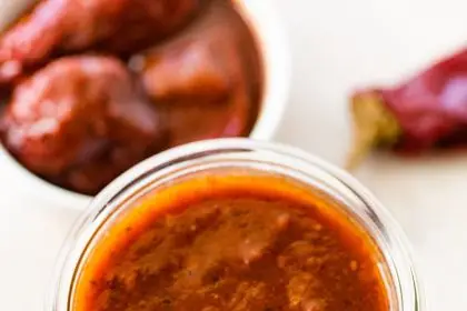 A glass weck jar filled with homemade red enchilada sauce.