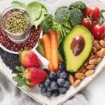Heart-shaped dish containing various plant-based foods